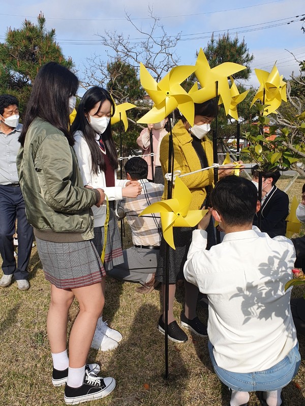 학생들이 세월호 추모 8주기를 맞아 희망의 노란 바람개비를  설치하고 있다.(사진=진도교육지원청)